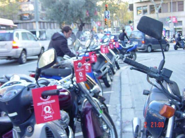 Reparto de publicidad impresa en pomos de viviendas y manillares de motos en zonas permitidas de Barcelona.